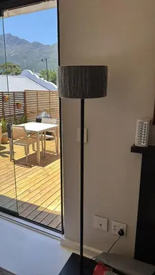 a floor lamp in a living room with a deck at Le Grenier Luxury Loft in Franschhoek