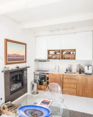 a kitchen with a glass table and a fireplace at Le Grenier Luxury Loft in Franschhoek