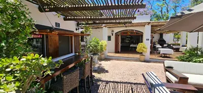 an outdoor patio with a table and chairs at De Leeuwenhof Estate in Paarl