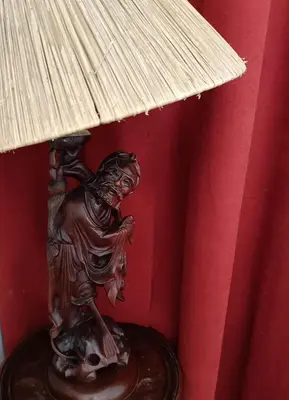 a bronze lamp on a table with a red wall at John Bauer Pottery Studio in Cape Town
