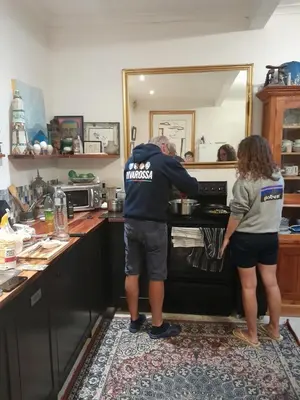 a man and a woman in a kitchen looking into an oven at John Bauer Pottery Studio in Cape Town