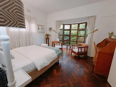 a bedroom with a white bed and a large window at John Bauer Pottery Studio in Cape Town