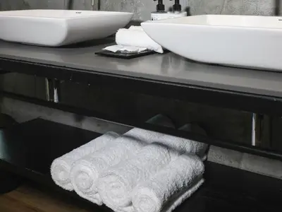 a bathroom with a sink and towels on a counter at Century City Hotel Urban Square in Cape Town