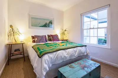 a bedroom with a bed and a window at The Vishuis in Hermanus