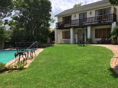 a house with a yard with a pool at Golf and Garden Guesthouse in Somerset West