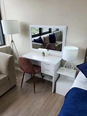 a bedroom with a desk and a bed and a mirror at Manhattan Luxury Apartments in Cape Town