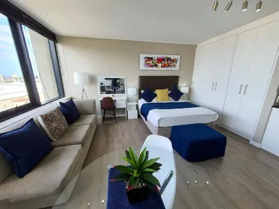 a hotel room with a bed and a couch at Manhattan Luxury Apartments in Cape Town