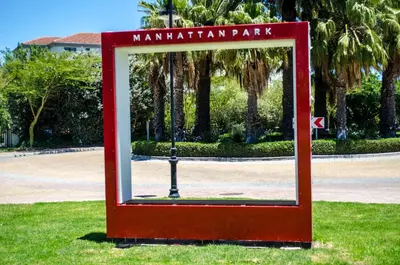 a red sign for a manhattan park in the grass at Manhattan Luxury Apartments in Cape Town