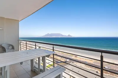 a balcony with a view of the beach at The Waves 1002 in Bloubergstrand