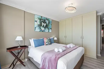 a bedroom with a bed with two towels on it at The Waves 1002 in Bloubergstrand