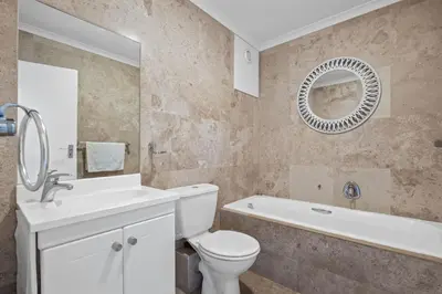 a bathroom with a toilet and a sink and a tub at The Waves 1002 in Bloubergstrand