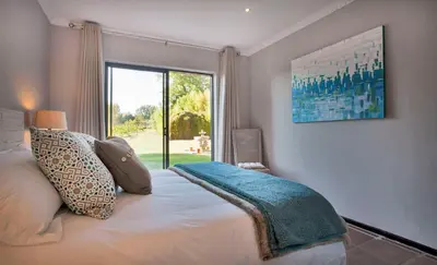a bedroom with a bed and a large window at Rest at Chabivin in Stellenbosch