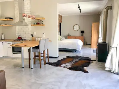 a kitchen and dining room with a table and a bed at Rest at Chabivin in Stellenbosch