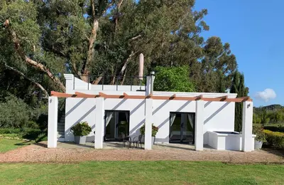 a white house with a balcony on top of it at Rest at Chabivin in Stellenbosch
