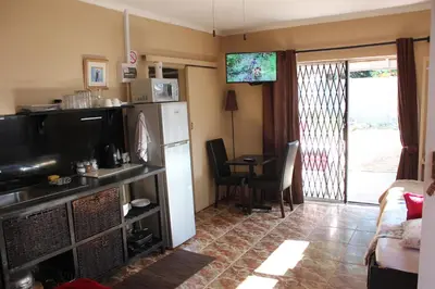 a kitchen with a refrigerator and a table with a chair at 25 on Fitzpatrick in Parow
