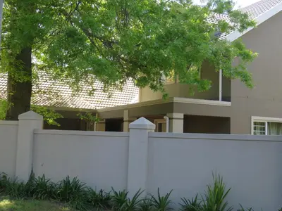 a white fence in front of a house at Milas Place in Somerset West