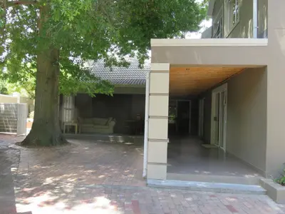 an open entry way to a house with a tree at Milas Place in Somerset West