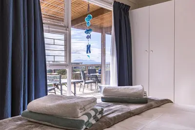 a bedroom with a bed with two pillows on it at The Mermaid's Tail in Pringle Bay