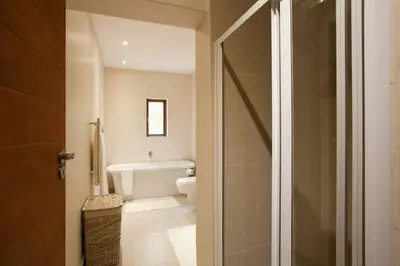a bathroom with a toilet and a bath tub at Viettz Suite in Stellenbosch