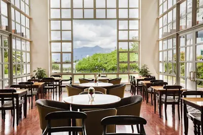 a restaurant with tables and chairs and large windows at City Lodge Hotel GrandWest in Epping