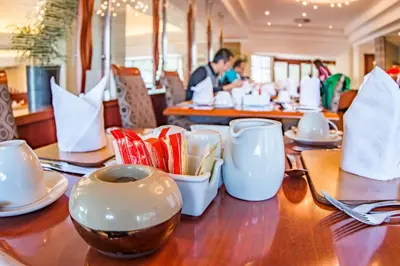 a wooden table with plates and cups on it at City Lodge Hotel Pinelands in Cape Town