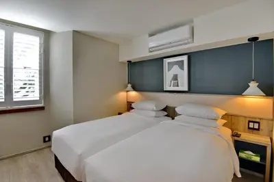 a bedroom with a large white bed and a window at Town Lodge Bellville in Bellville