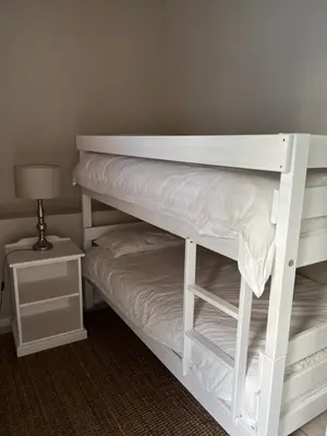 a white bunk bed in a room with a lamp at Hartebeeskraal Selfcatering cottage in Paarl