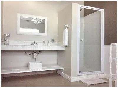a bathroom with a sink and a shower with a mirror at Hartebeeskraal Selfcatering cottage in Paarl