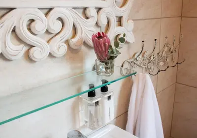 a bathroom with a sink and a vase of flowers at Avemore Wag n Bietjie No 1 in Stellenbosch