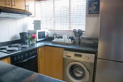 a kitchen with a washing machine and a stove at Avemore Wag n Bietjie No 1 in Stellenbosch