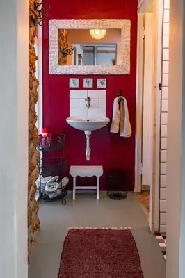 a red bathroom with a sink and a mirror at Belfield Wines and Farm Cottages in Grabouw