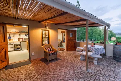 a patio with a table and chairs and a kitchen at Belfield Wines and Farm Cottages in Grabouw