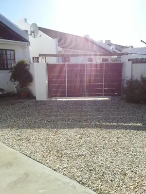 a red fence in front of a house at Rose Cottage in Hermanus