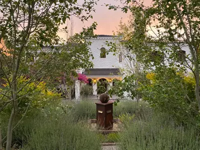 a house with a fountain in the middle of a yard at Montrose Guesthouse in Somerset West