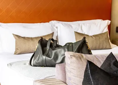 a black purse sitting on top of a bed at Silver Forest Boutique Hotel and Spa in Somerset West