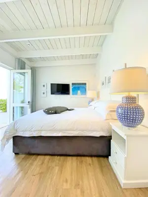 a white bedroom with a large bed and a lamp at One Marine Drive Boutique Hotel & Spa by The Living Journey Collection in Hermanus