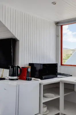 a kitchen with a counter with a microwave and a window at Beautiful Abalone in Hermanus