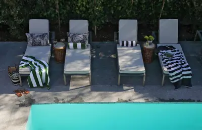 a group of chairs sitting next to a swimming pool at Twice Central Guest House in Stellenbosch