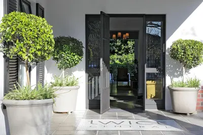 an entrance to a building with potted trees in pots at Twice Central Guest House in Stellenbosch