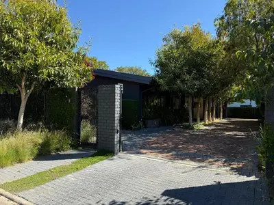 a driveway leading to a house with a fence at Twice Central Guest House in Stellenbosch