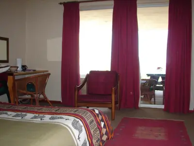 a bedroom with purple curtains and a bed and a desk at Shirleys Place in Brackenfell