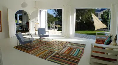 a living room with two chairs and a rug at Pashasha Beach House and Hot Tub in Hermanus