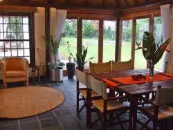 a dining room with a wooden table and chairs at KaapsePracht Bed & Breakfast in Somerset West