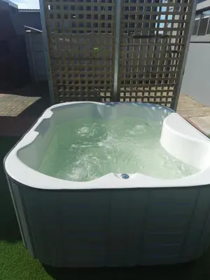 a jacuzzi bath tub with green water in it at Stukkie Cottage in Hermanus