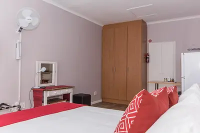 a bedroom with a bed with red and white pillows at 10 Windell Self Catering Accommodation in Durbanville