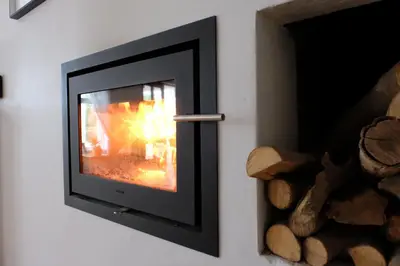 a television with a fire in a wall at Vine Guesthouse in Stellenbosch