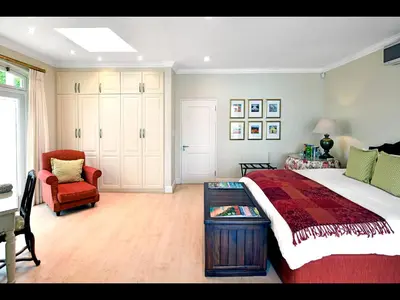 a bedroom with a large bed and a chair at 10 Villefranche in Franschhoek