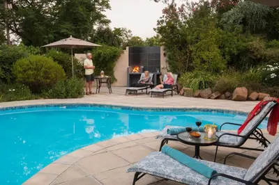 a group of people sitting around a swimming pool at SomerZicht Guest House in Somerset West