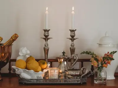 a table with two candles and a tray of fruit at Le Petit Paris in Franschhoek