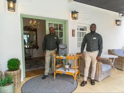 two men standing in a living room with a machine at Le Petit Paris in Franschhoek